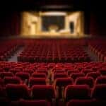 The inside of the theater with seats and the stage in view