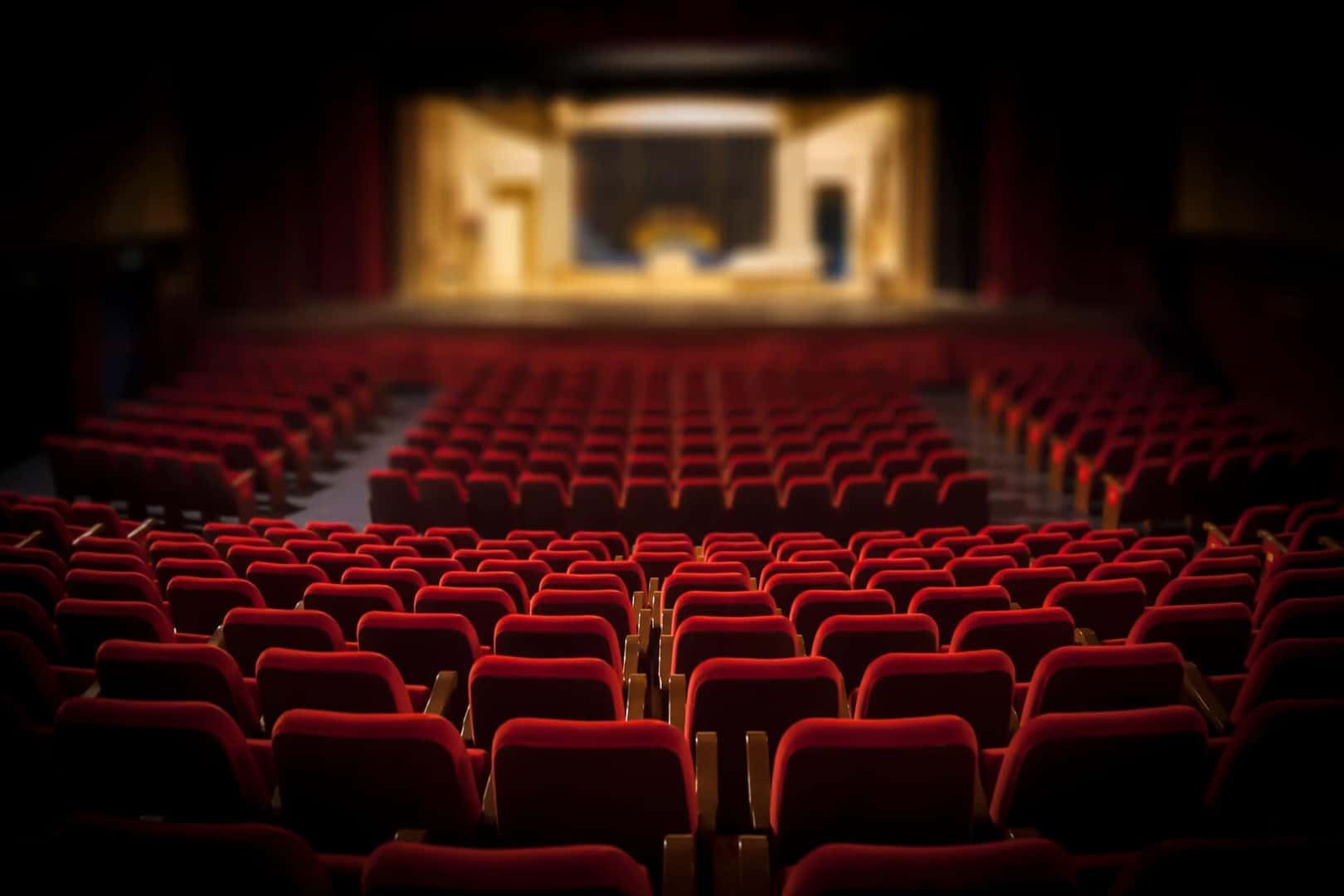The inside of the theater with seats and the stage in view