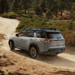 2025-nissan-pathfinder-rear-view-driving-down-dirt-road
