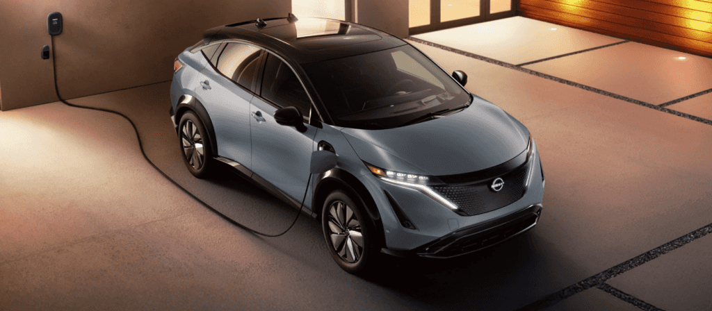 Nissan ARIYA siendo cargado desde una casa