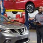 Nissan technician with a tablet in a Nissan service bay
