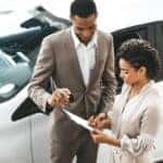 Car dealer showing a customer paperwork