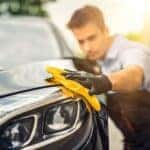 Man waxing a car exterior