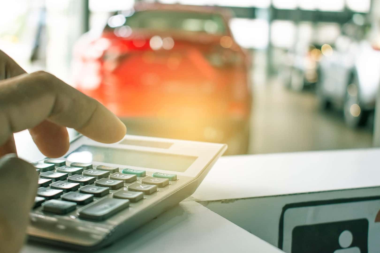 Person calculating car financing in dealership