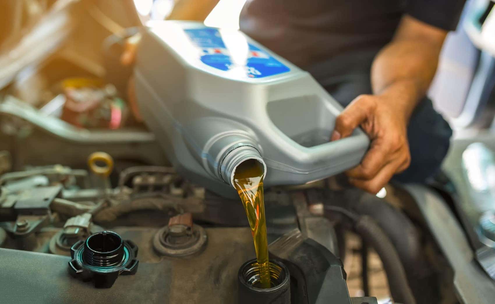 Technician filling engine with new oil