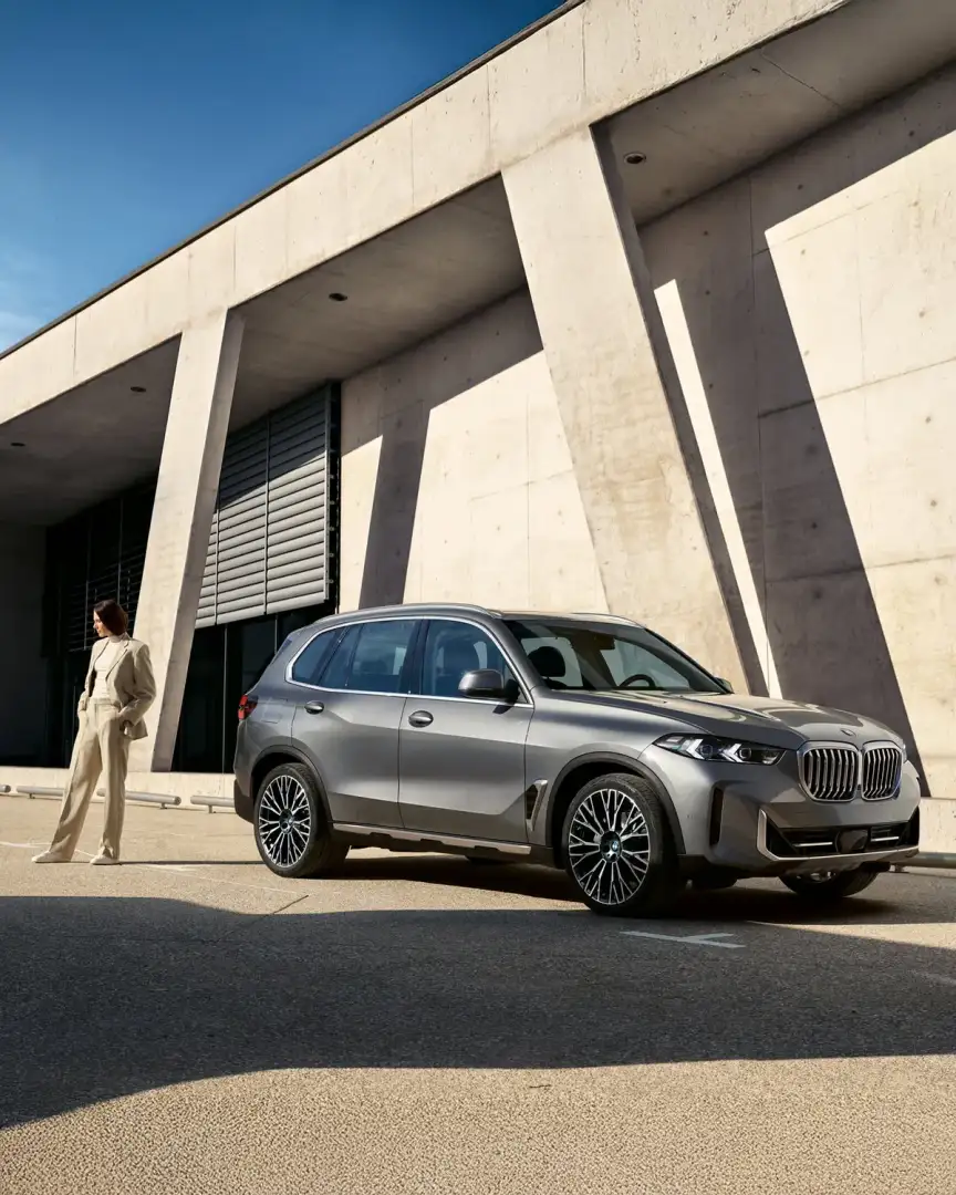 BMW X5 side profile outside a contemporary building