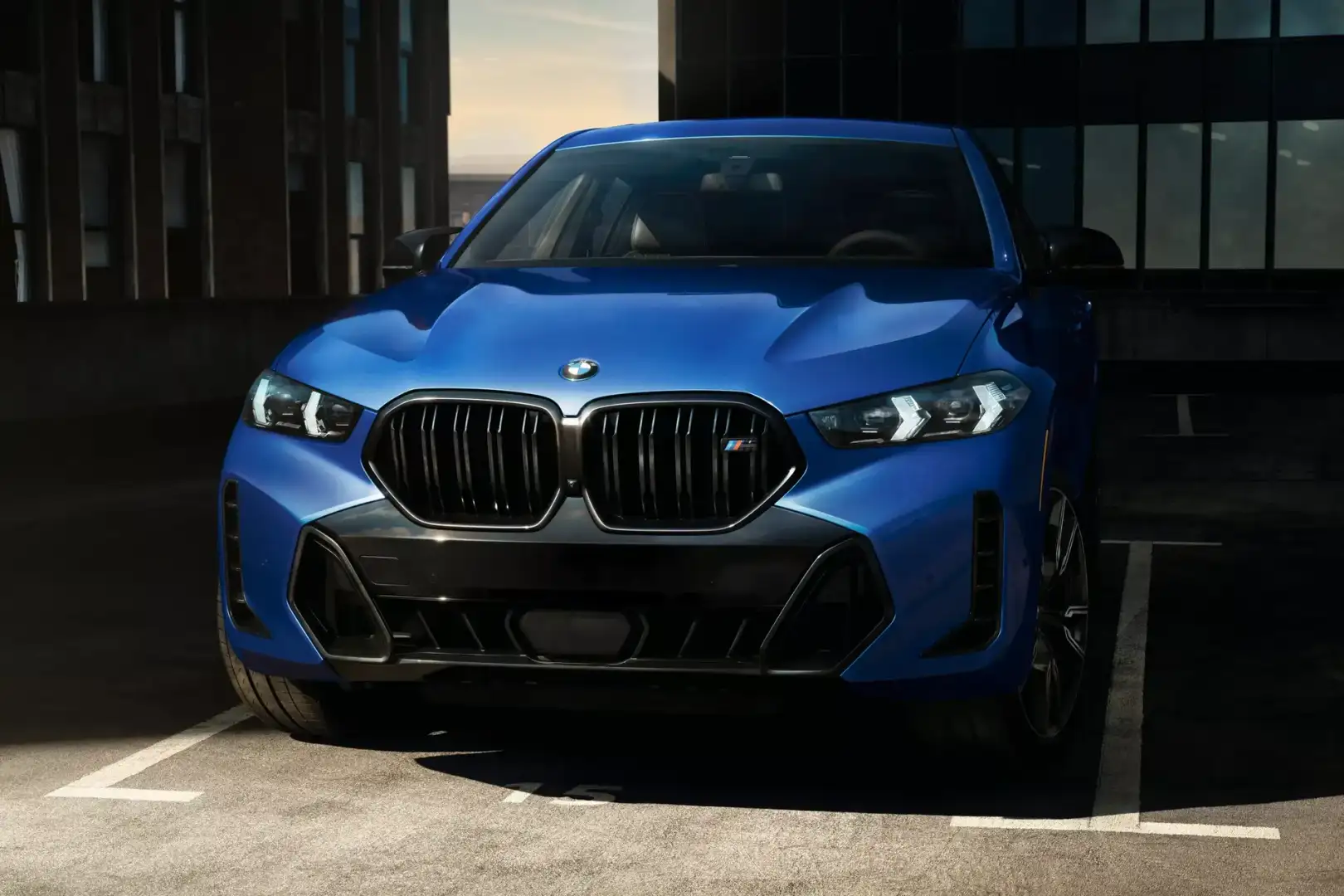 A blue BMW X6 Sports Activity Coupe, front view in dramatic light
