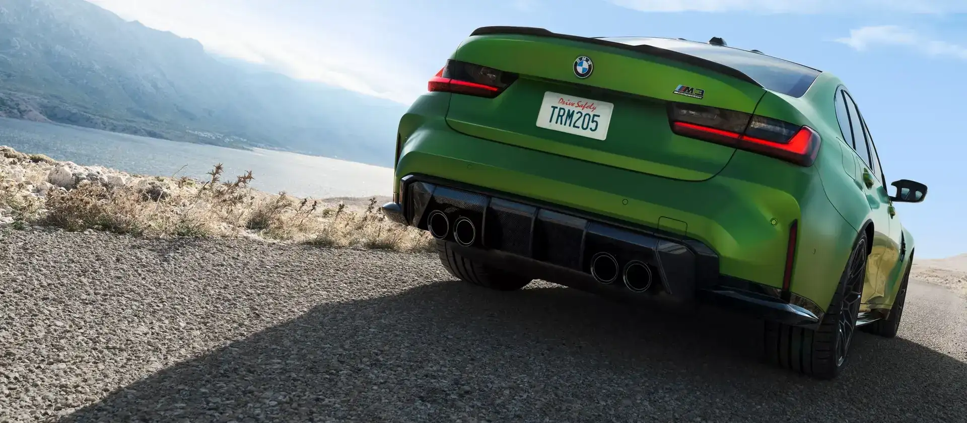 BMW M3 Competition in Isle of Man Green, rear three-quarter, with the M quad exhaust and carbon diffuser