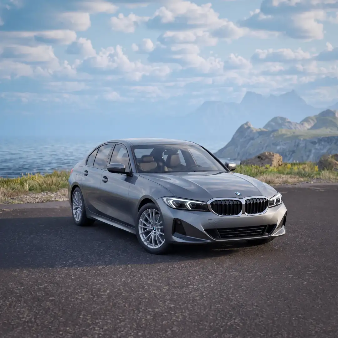 A gray BMW 3 Series sedan on a coastal road