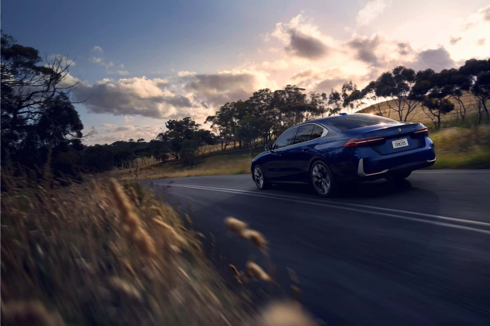 A BMW 5 Series driving along a country road