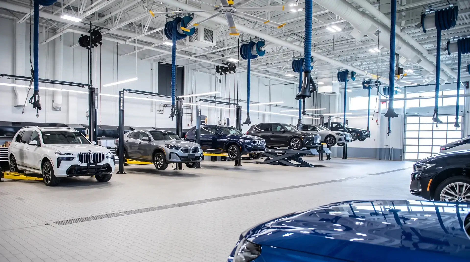 The service workshop at BMW of Fort Walton Beach, with BMWs raised on lifts across the bays