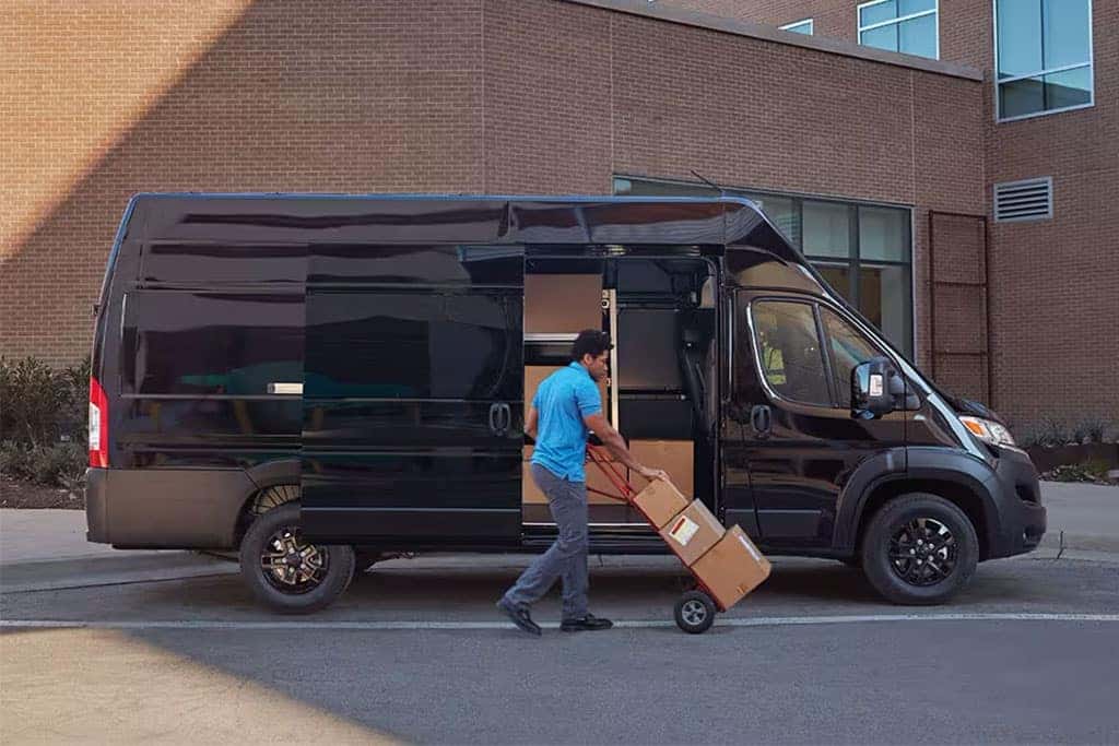 Delivery worker taking out boxes from a black Ram ProMaster