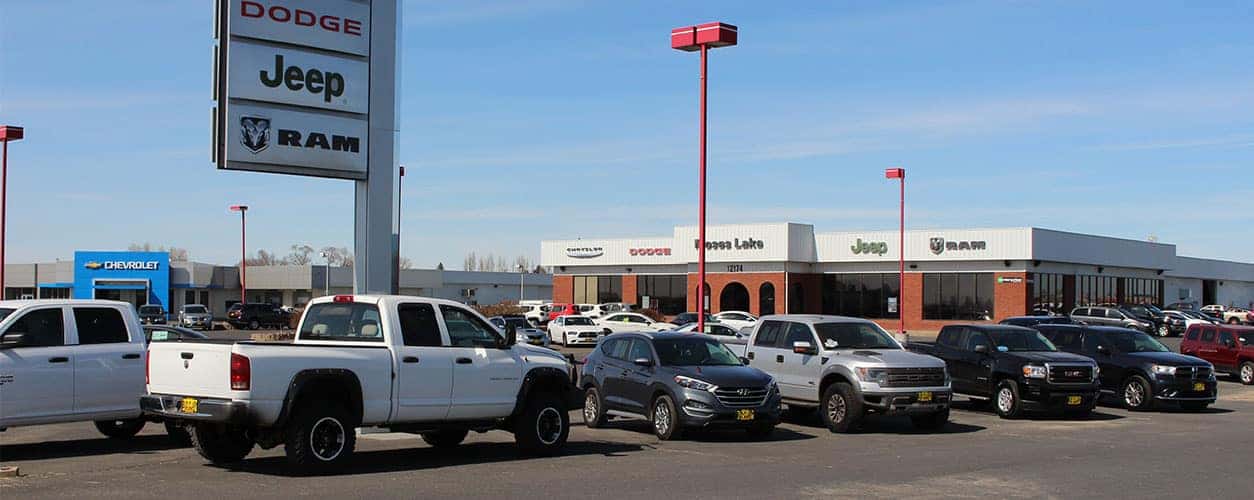 Front entrance of Bud Clary Moses Lake CDJR with new and used vehicles parked in the parking lot