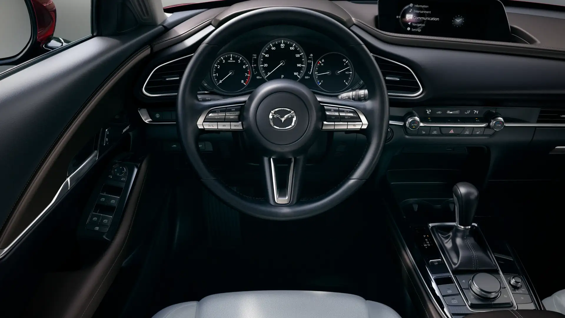 2026 Mazda CX-30 cockpit with Mazda steering wheel, gauges, infotainment screen, and console