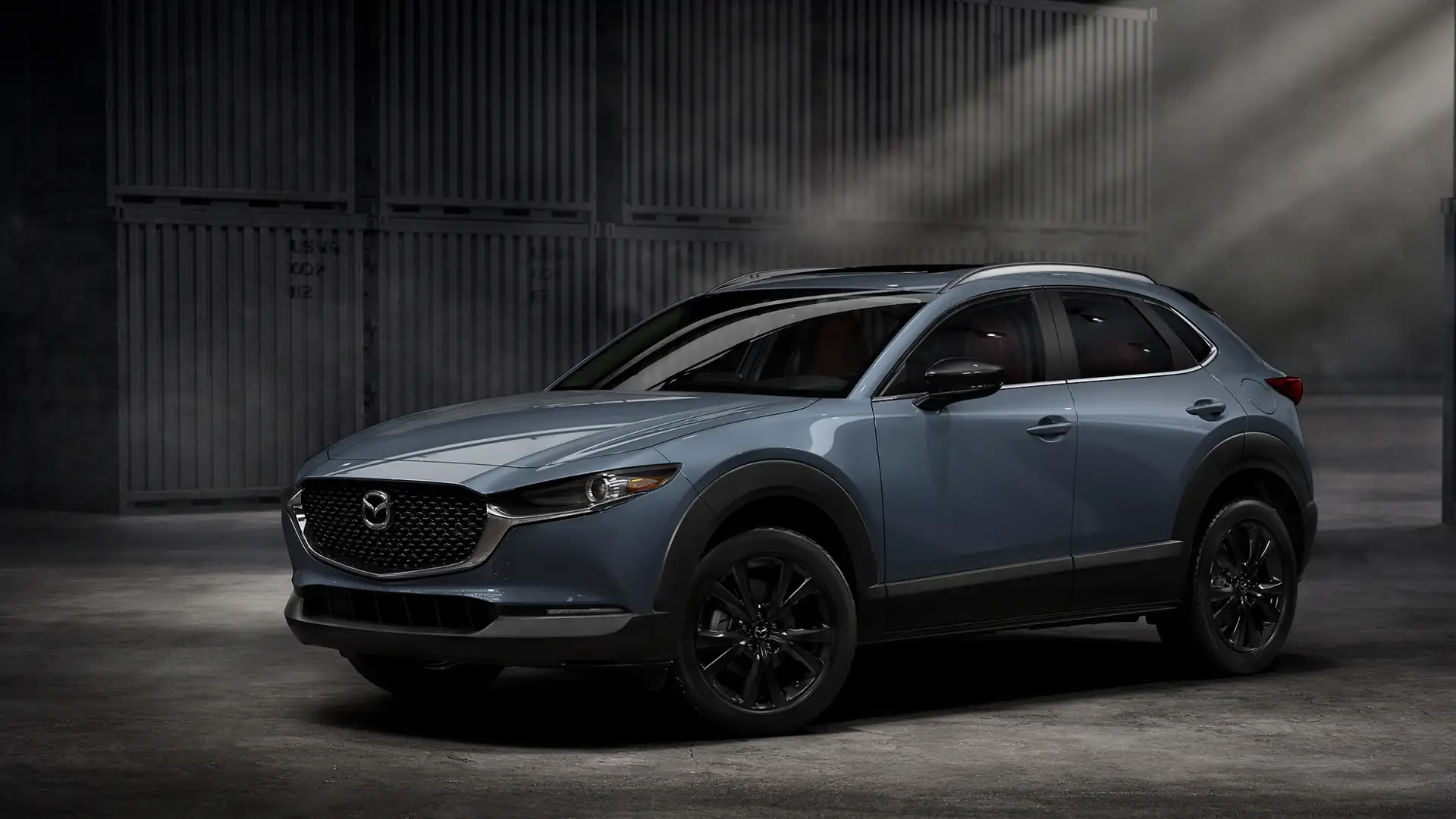 2026 Mazda CX-30 blue SUV in studio lighting with black wheels, roof rails, and sculpted body