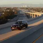 2026 Mazda CX-90 red SUV driving on elevated highway ramp with city skyline in the distance
