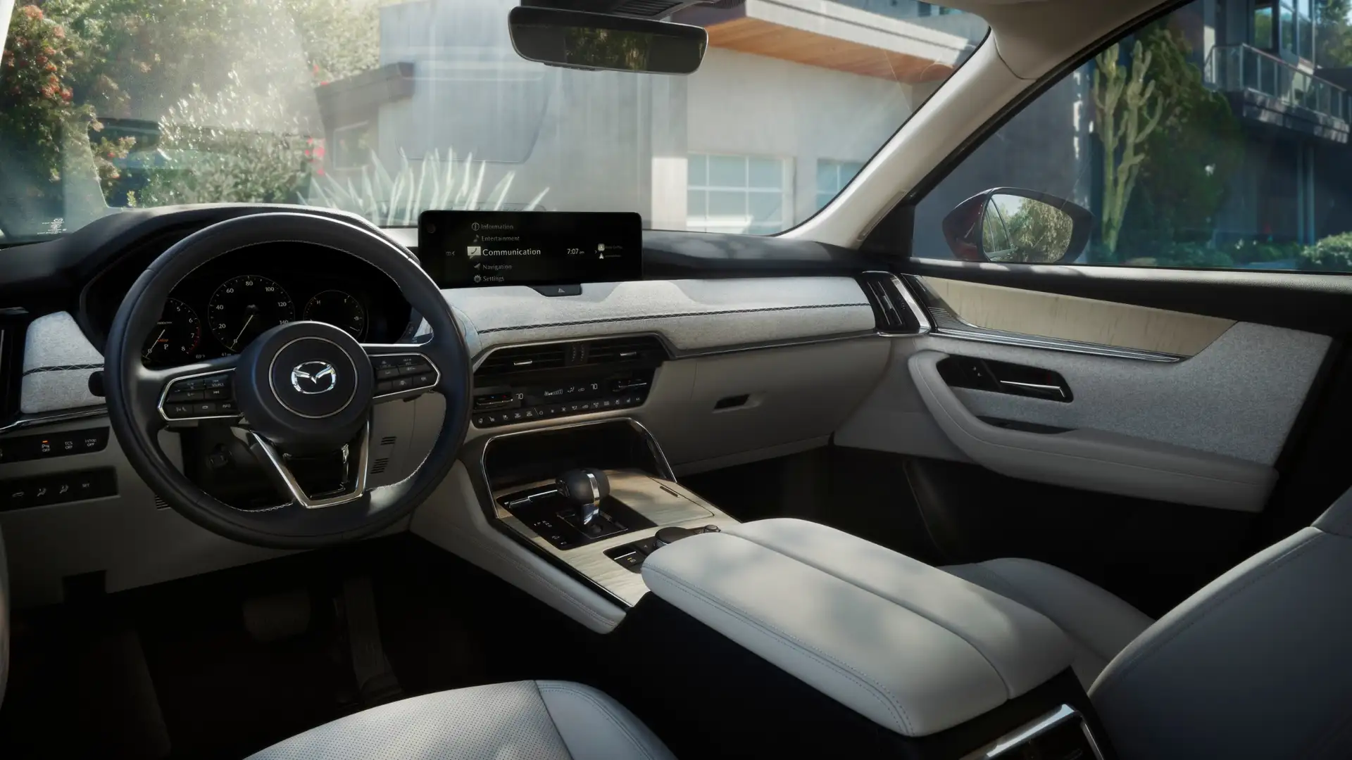 2026 Mazda CX-90 driver cockpit with white seats, digital screen, wood trim, and modern dash