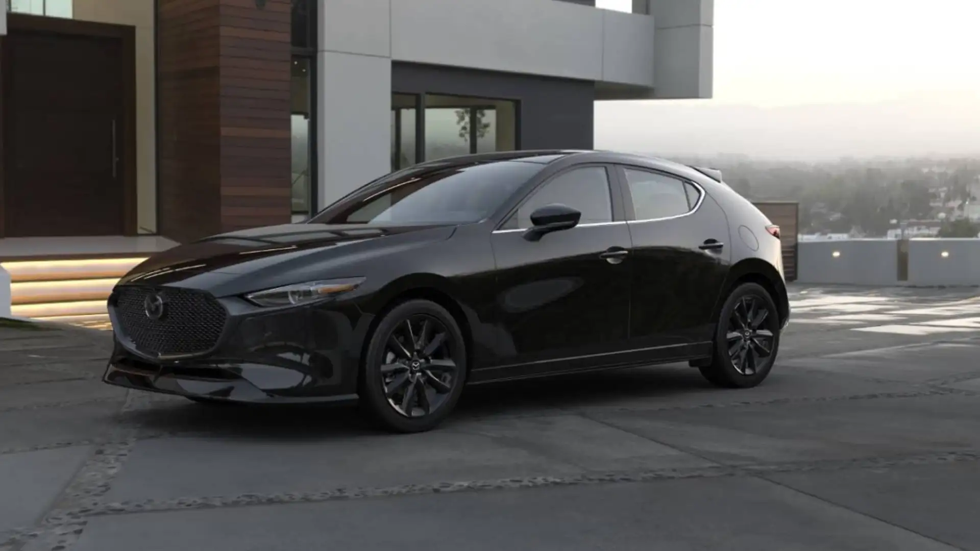 2026 Mazda3 Hatchback black exterior parked outside modern hillside home with dark alloy wheels