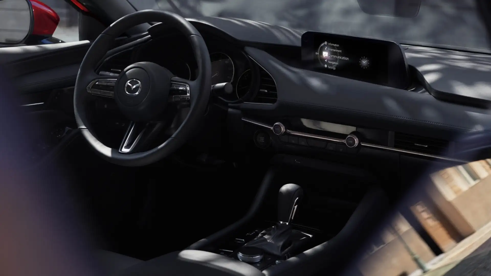 2026 Mazda3 Sedan dark dashboard with steering wheel, infotainment screen, gear shifter, and vents