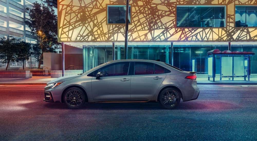 A white 2021 Toyota Corolla Apex is driving through a city after leaving a Toyota Corolla dealer.