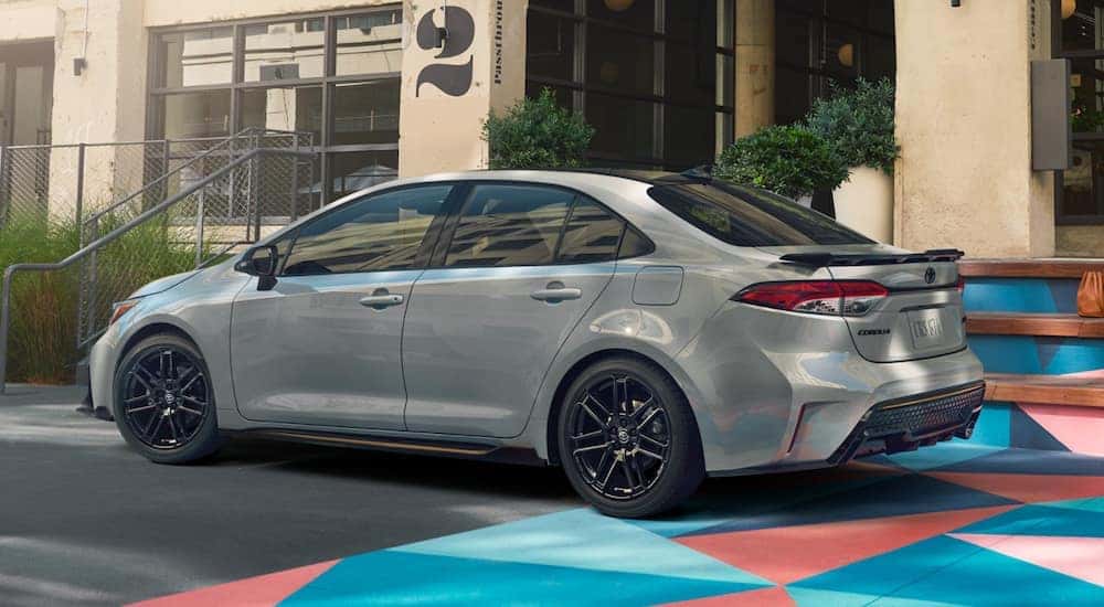 A white 2021 Toyota Corolla Apex is shown from the side parked on a city street.