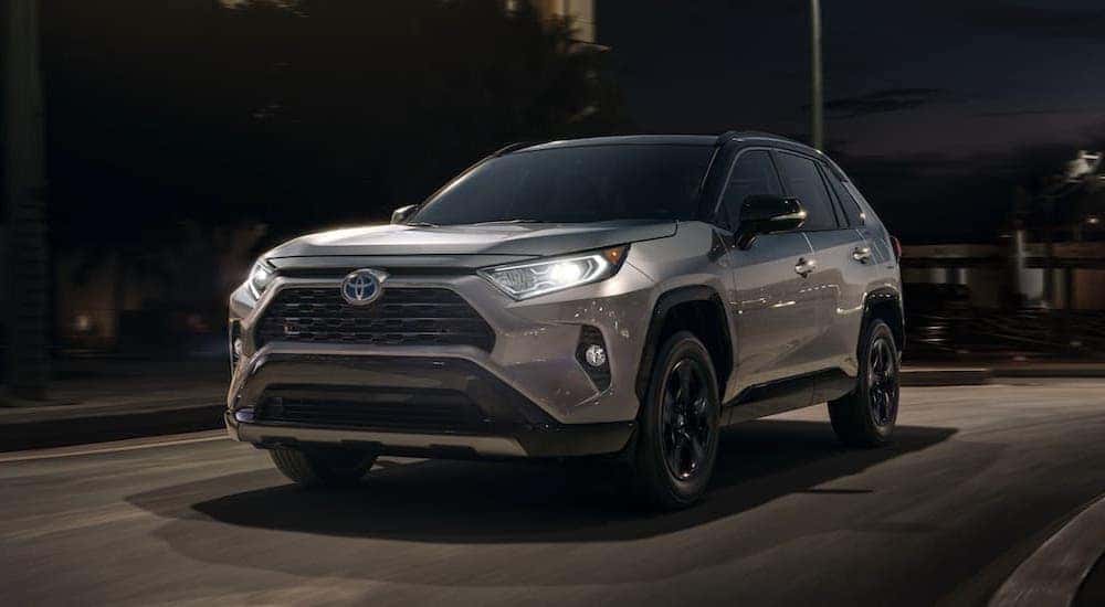 A grey 2020 Toyota RAV4 is shown driving at night.
