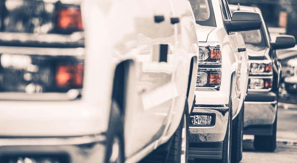 Three trucks are shown from a low angle at a used truck dealership in PA.