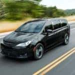 If you're looking for a used car dealer near you, then you could find this black 2019 Chrysler Pacifica, which is driving on a highway.