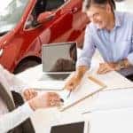 A couple is going over paper work for a 5-minute car loan with a salesman at a dealership in Defiance, OH.