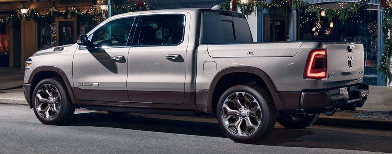 A silver 2020 Ram 1500 is parked on a city street at night.