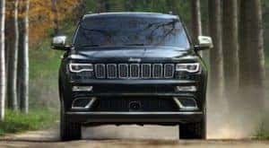 A black 2019 Jeep Grand Cherokee is driving on a dirt road near Findlay, OH.