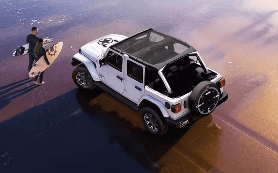 2026 Jeep Wrangler parked on beach near surfers