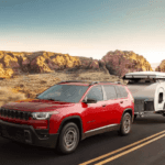 Jeep Cherokee towing camper on desert highway