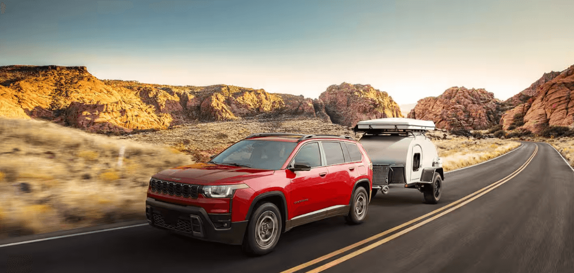 Jeep Cherokee towing camper on desert highway