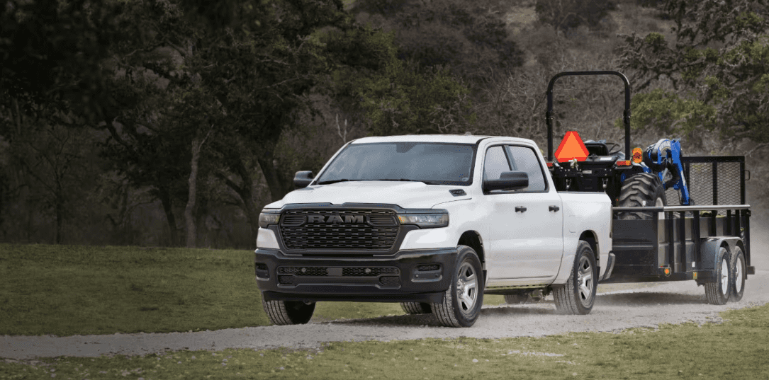 Ram 1500 towing utility trailer on gravel road