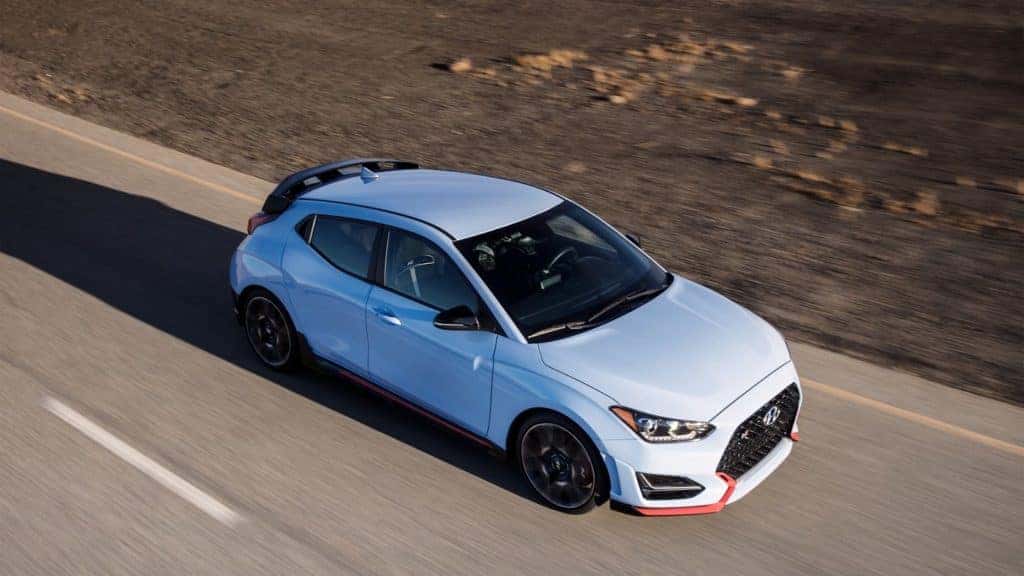 Blue 2022 Hyundai Veloster N driving down a desert road