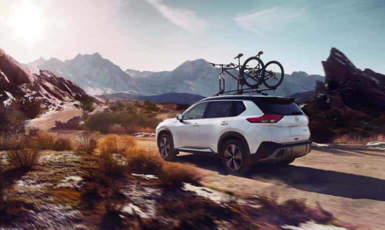 2023 Nissan Rogue offroading in desert with bikes on top