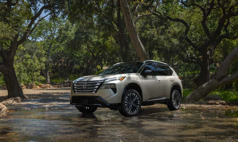 2026 Nissan Rogue Exterior Driving Through Forest