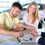 Couple signing paperwork with a dealer