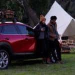 Couple standing by Mazda CX-30 by campground