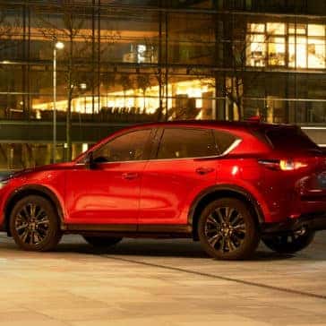 Red 2022 Mazda CX-5 Compact Crossover SUV parked in city at night in Fond du Lac