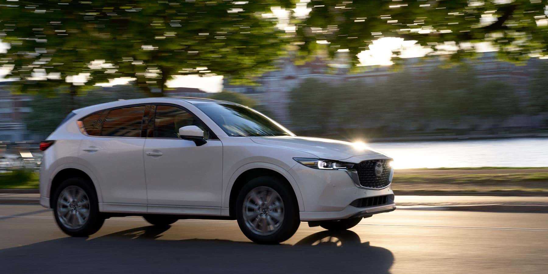 White 2022 Mazda CX-5 Compact Crossover SUV driving by river