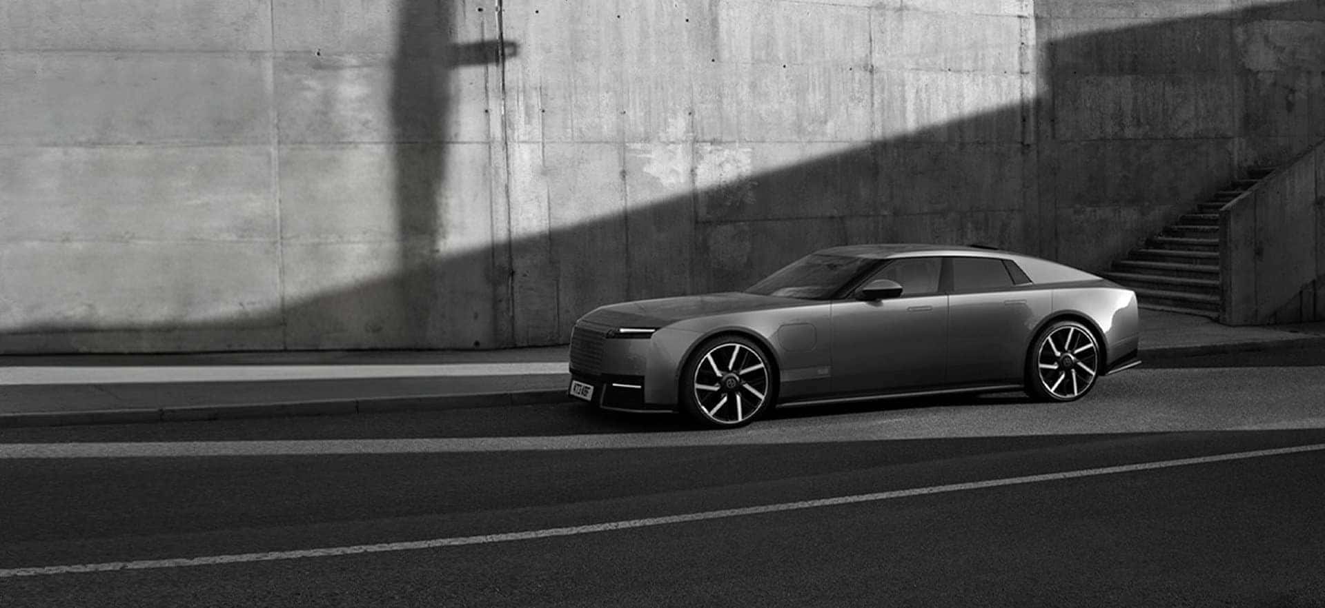 Jaguar Type 01 four-door Grand Tourer parked beside a concrete wall