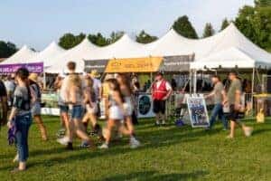 People walking in front of the Jeff Belzer's tent at Lakefront Music Fest