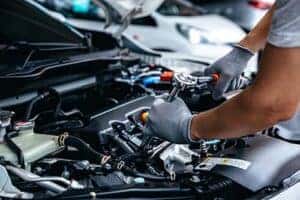 mechanic working on engine of vehicle