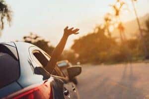 person in car with hand out the window