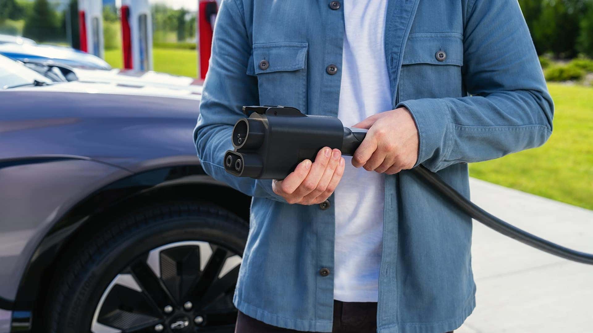 man holding electric vehicle charger