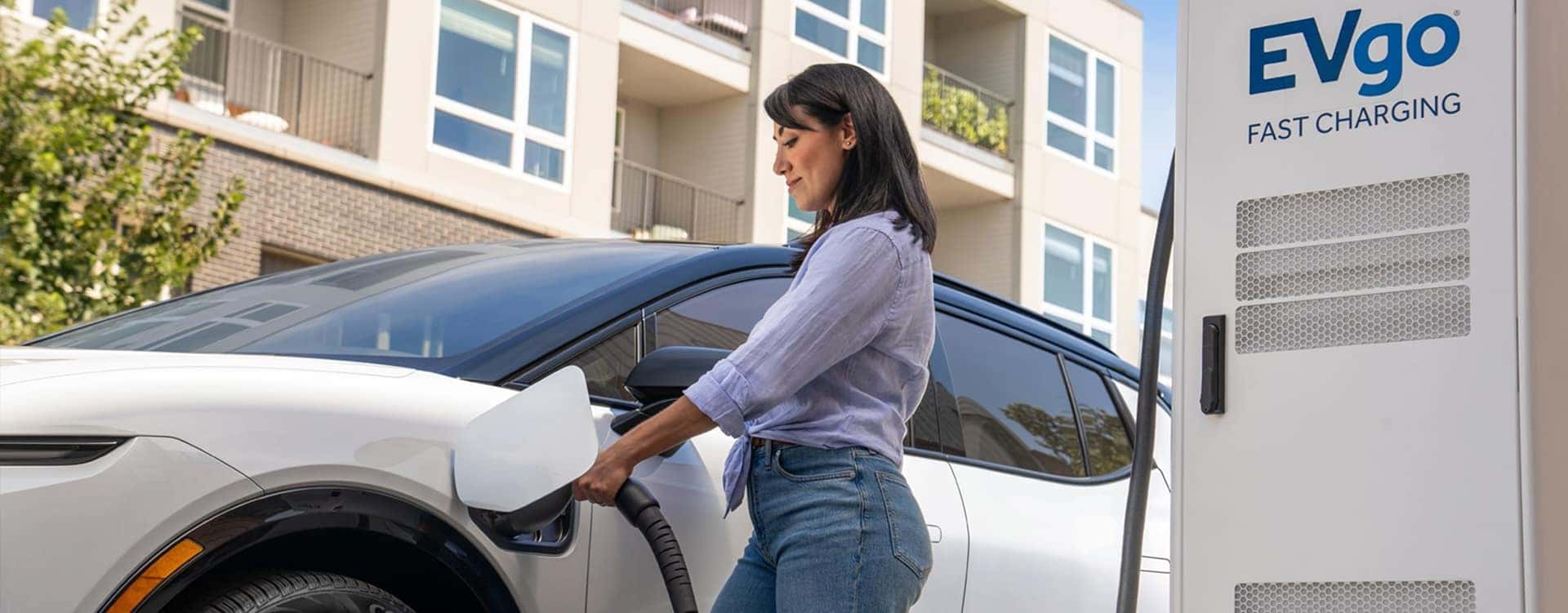 woman charging ev outside