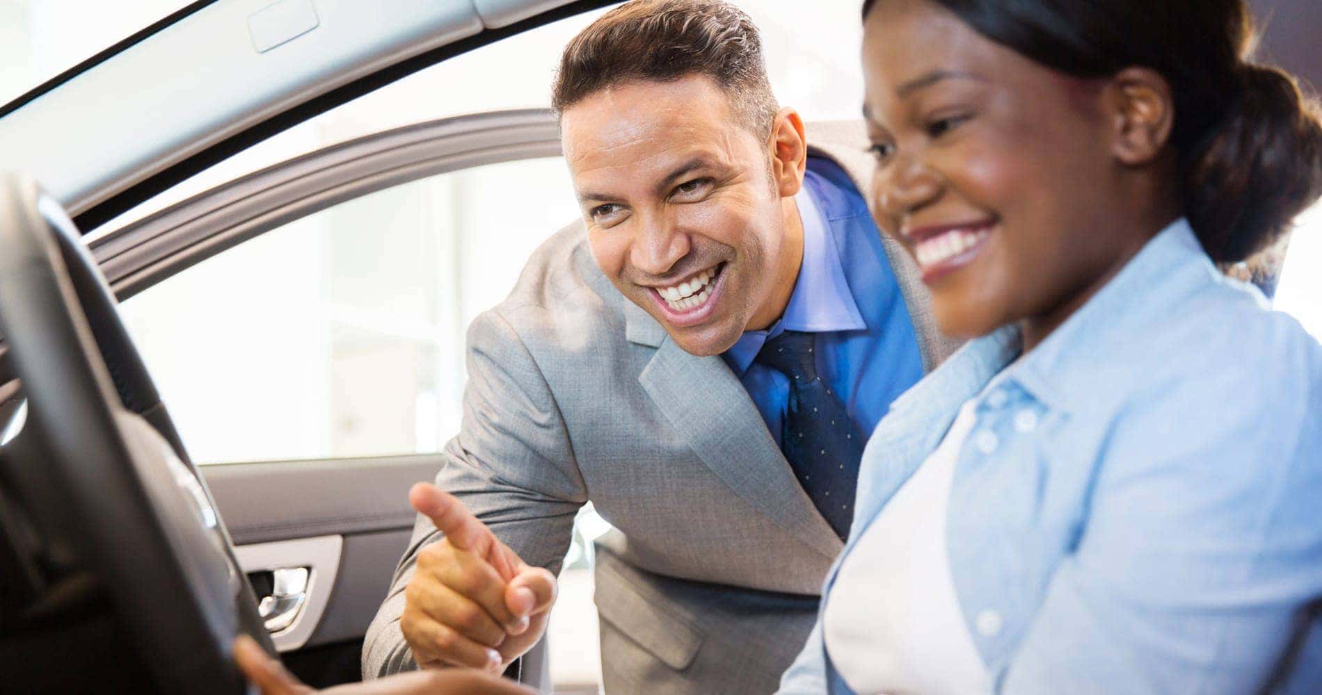 sales person talking to customer in car