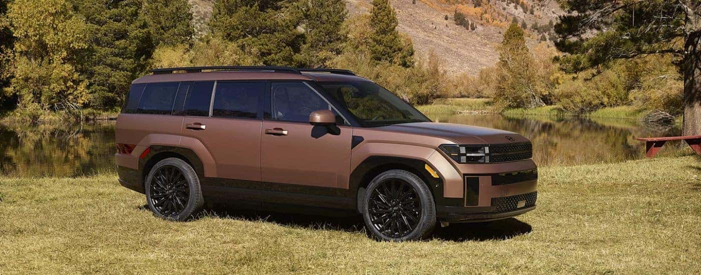 Brown 2026 Hyundai Santa Fe parked in front of a pond.